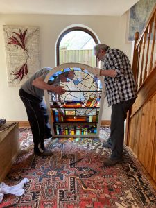 Stained Glass window installation with two people
