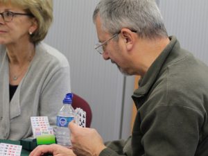 Man and woman playing card game bridge