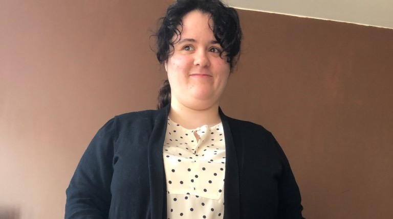 Woman in white spotty top and black cardigan