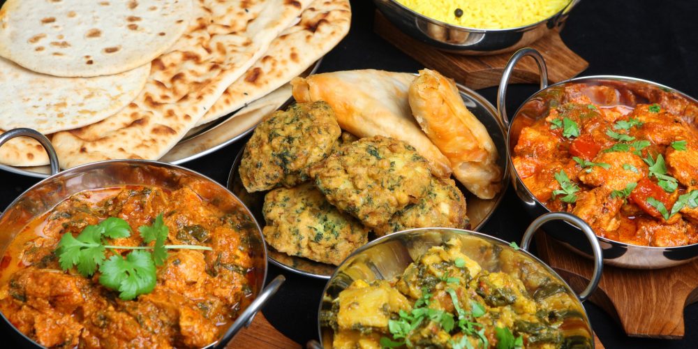 Four indian dishes and naan bread