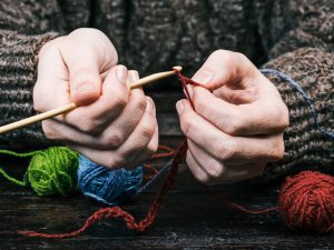 hands using wool to crochet with hook