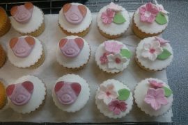 Cupcakes decorated with pig sweets and flowers