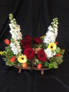 Flower arrangement with red roses, yellow gerberas and orange tulips