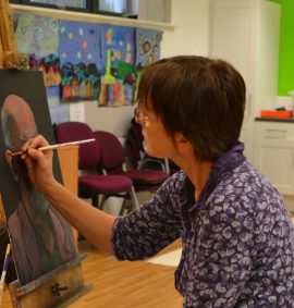 Woman painting a portrait of a man