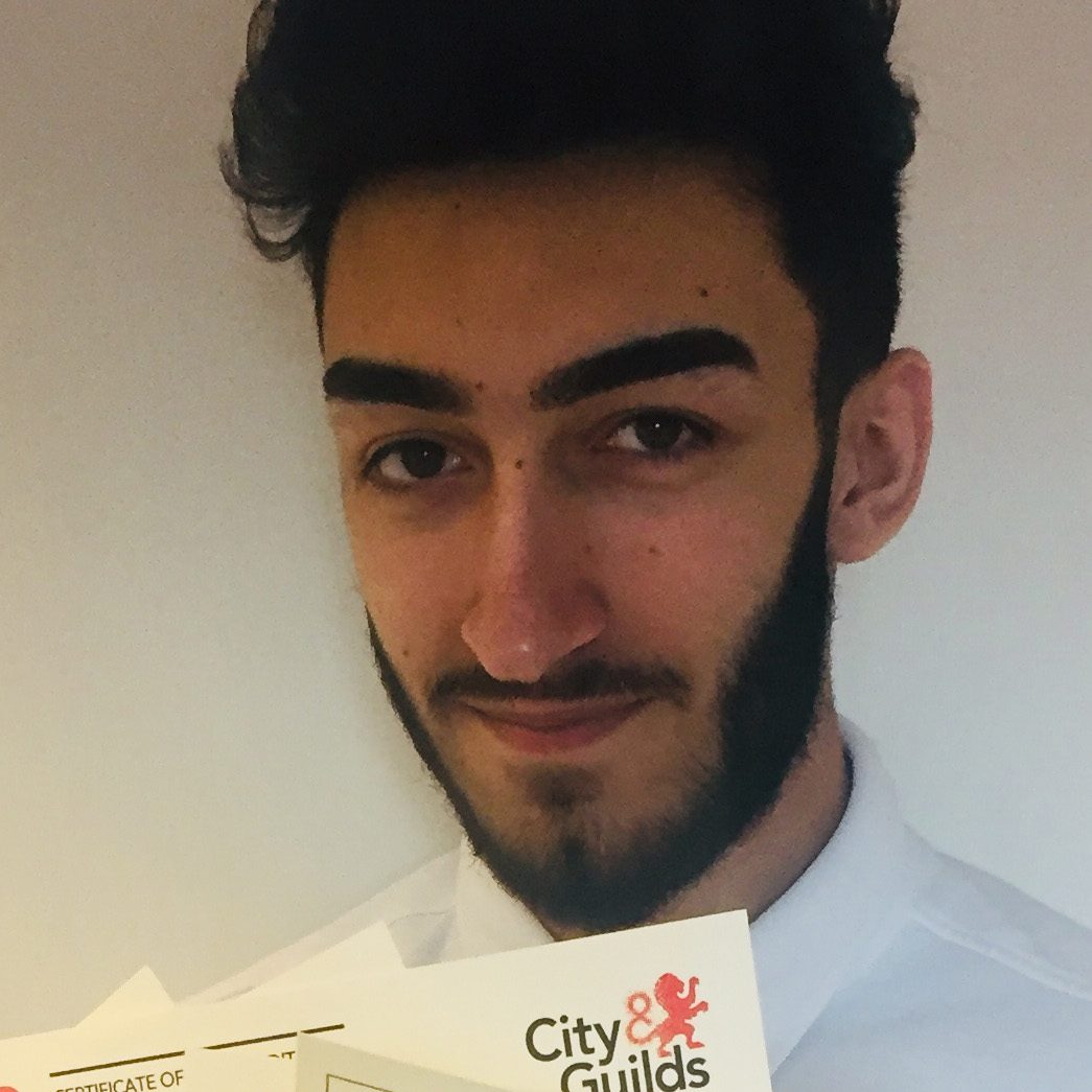 Young man with beard holding certificates