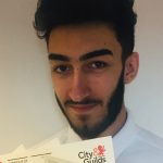 Young man with beard holding certificates