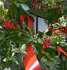 Christmas wreath with green foliage and red berries and ribbon