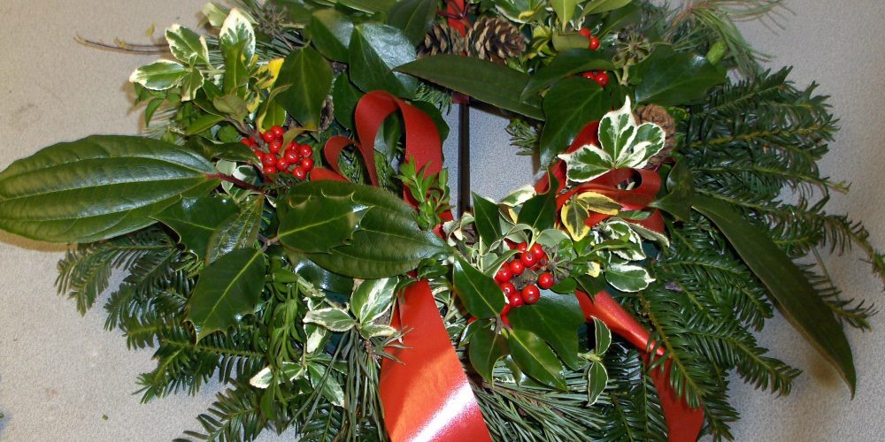 Christmas wreath with green foliage and red berries and ribbon