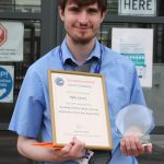 Young man with award and certificate