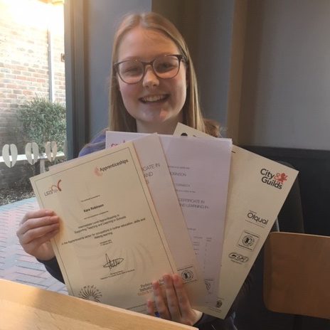 Girl with glasses and blond hair holding certificates