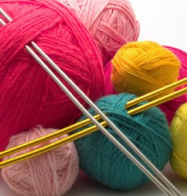 Balls of coloured wool with knitting needles