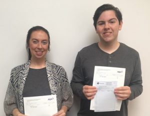A woman and young man holding GCSE certificates