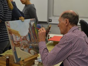 Man painting a canal scene on an easel
