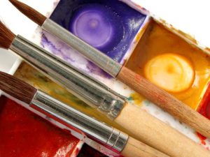 Three paintbrushes and paint palette