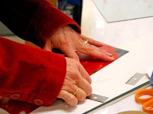 Woman cutting paper for a picture frame