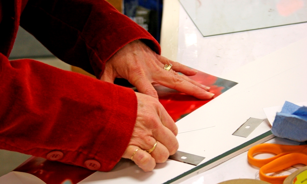 Woman cutting paper for a picture frame