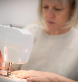 Woman in muslin pattern using sewing machine