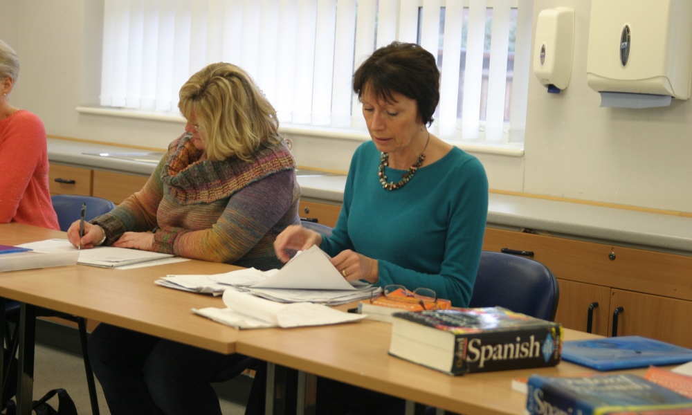Two women learning Spanish in a classroom