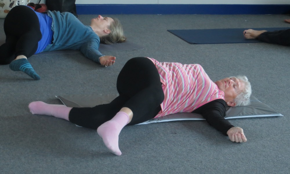 Two women lying down on yoga mats