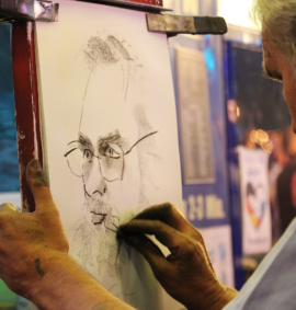a man drawing a portrait with charcoal