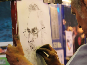 a man drawing a portrait with charcoal